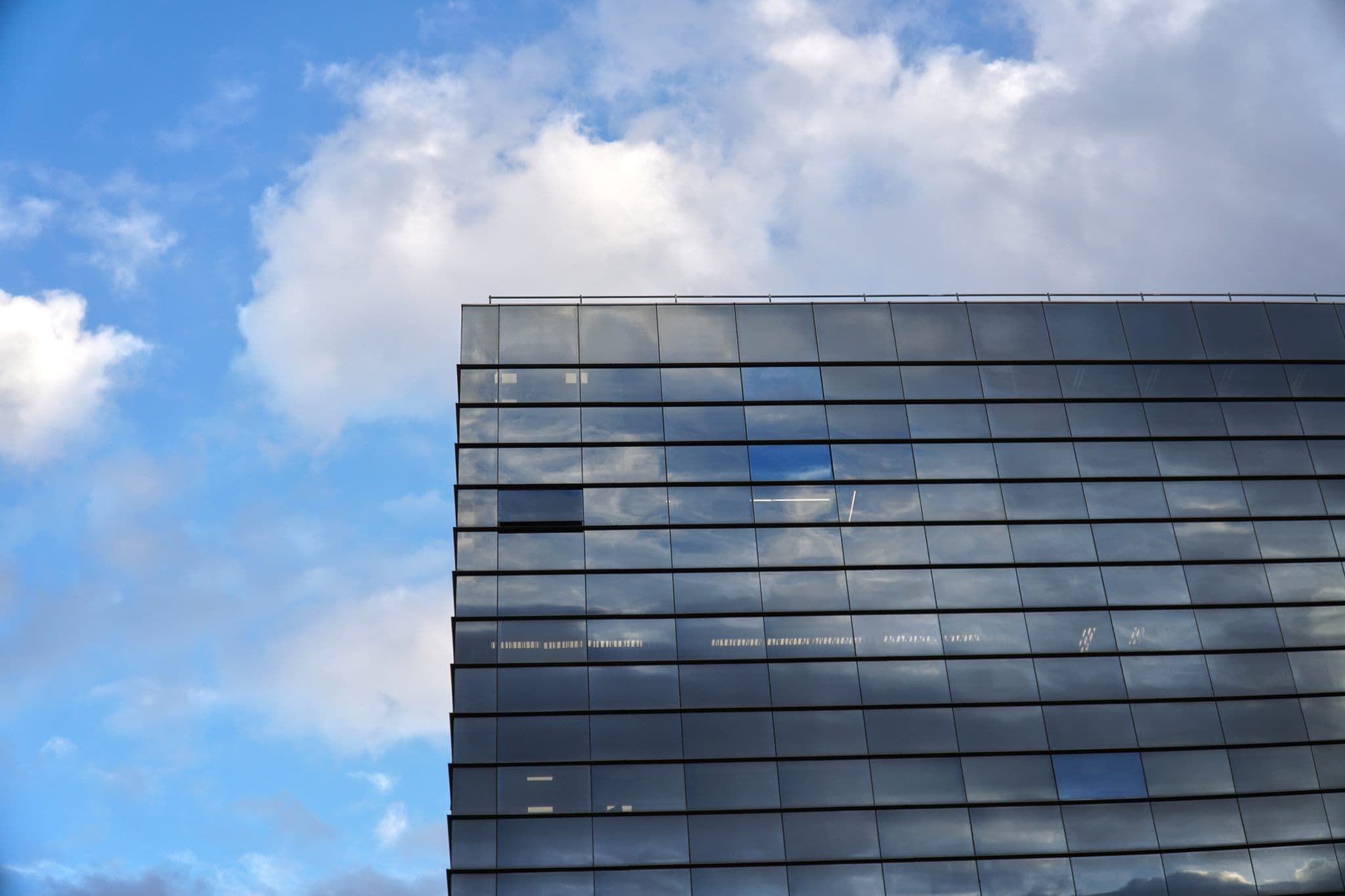Façade vitrée réfléchissante d'un immeuble de bureaux sous le ciel