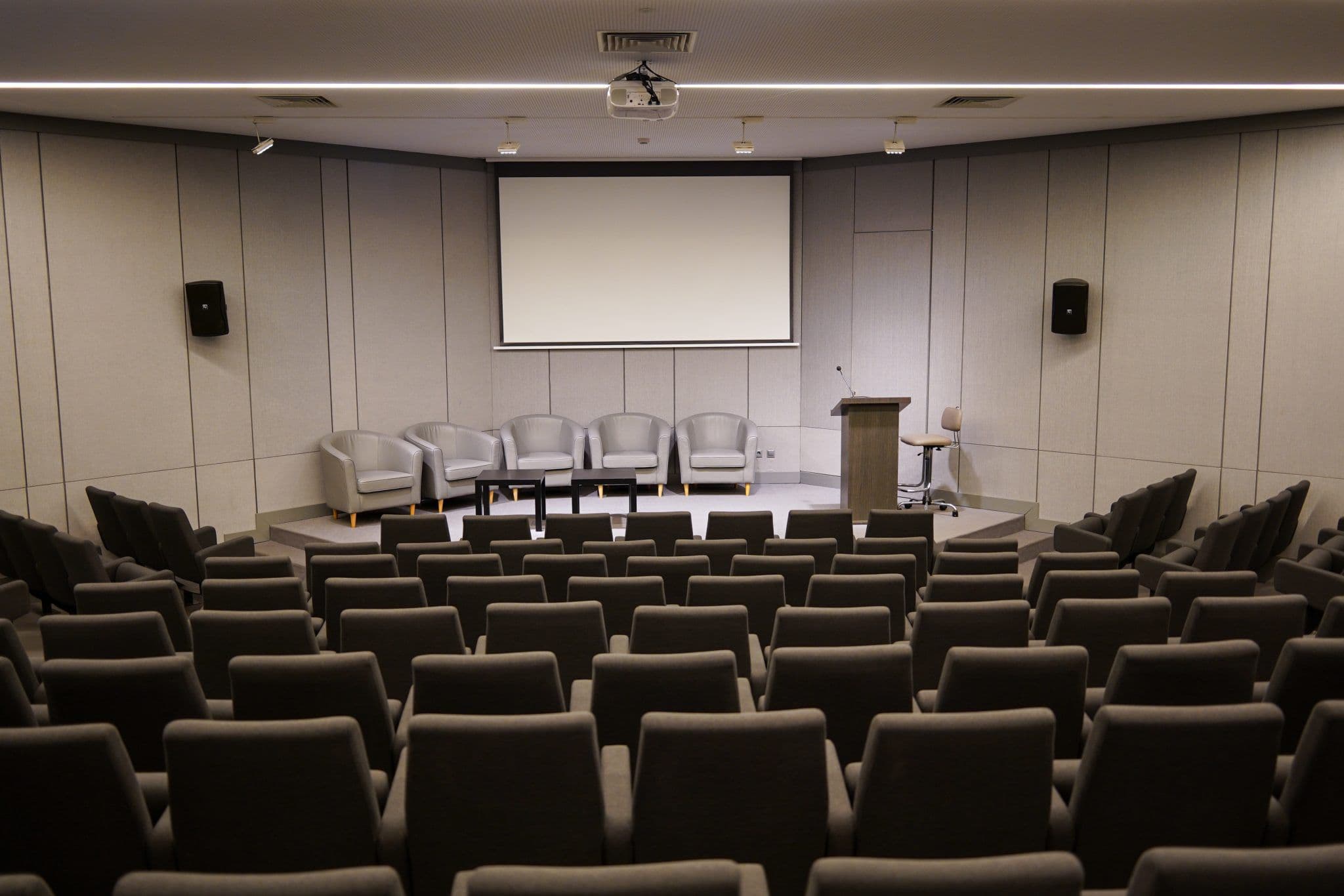 Salle de conférence vide avec écran et petite estrade